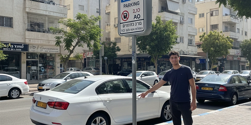 Street parking area in Ness Ziona near shops and residential buildings
